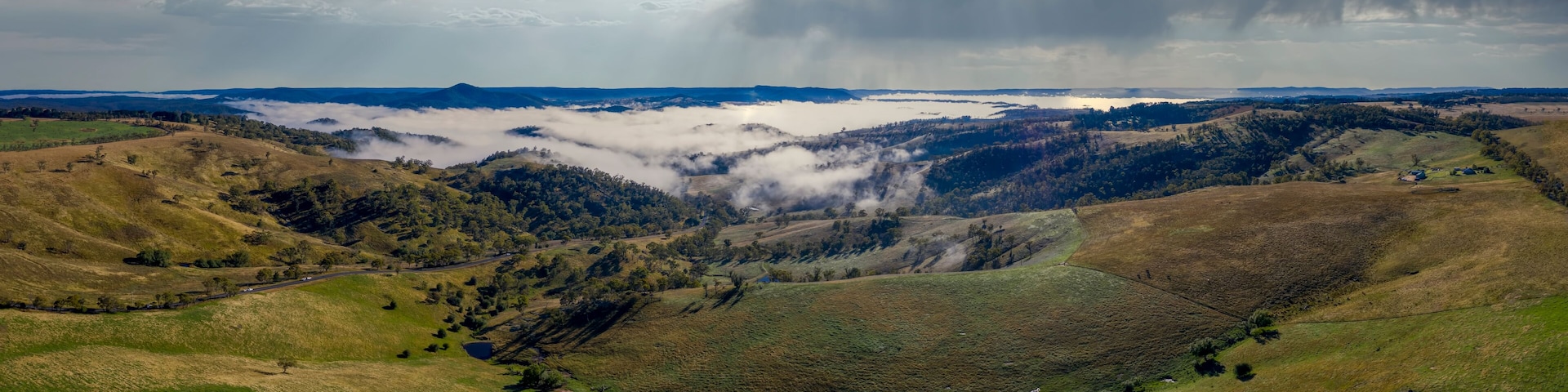 Aerial view of low-level clouds in a large green valley in regional Australia
