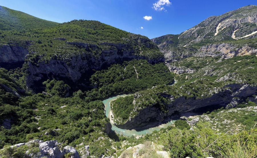 Eine gebirgige Landschaft mit einem Fluss, der sich durch ein Tal schlängelt.