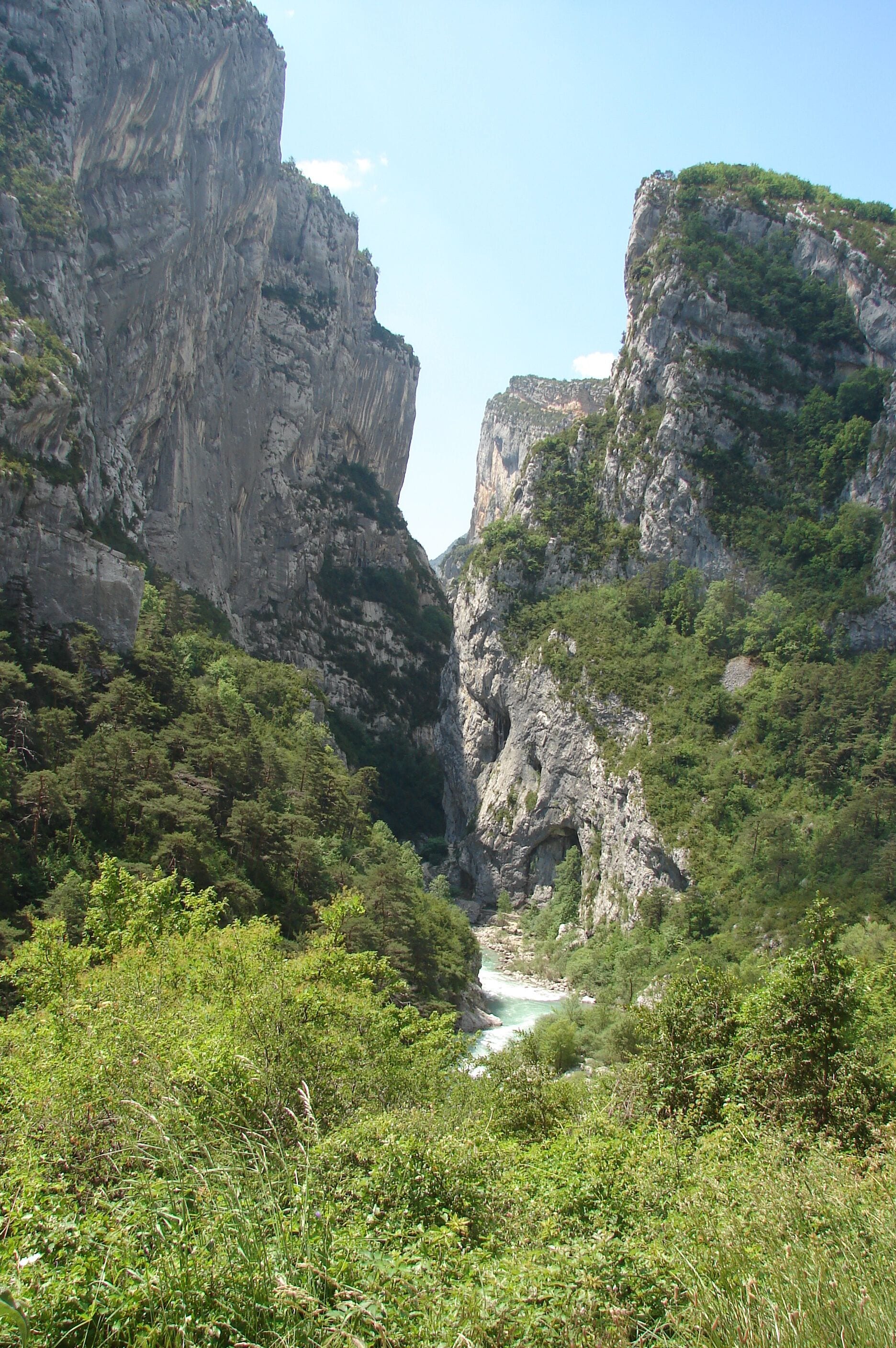 A canyon with steep cliffs and a river flowing through it.