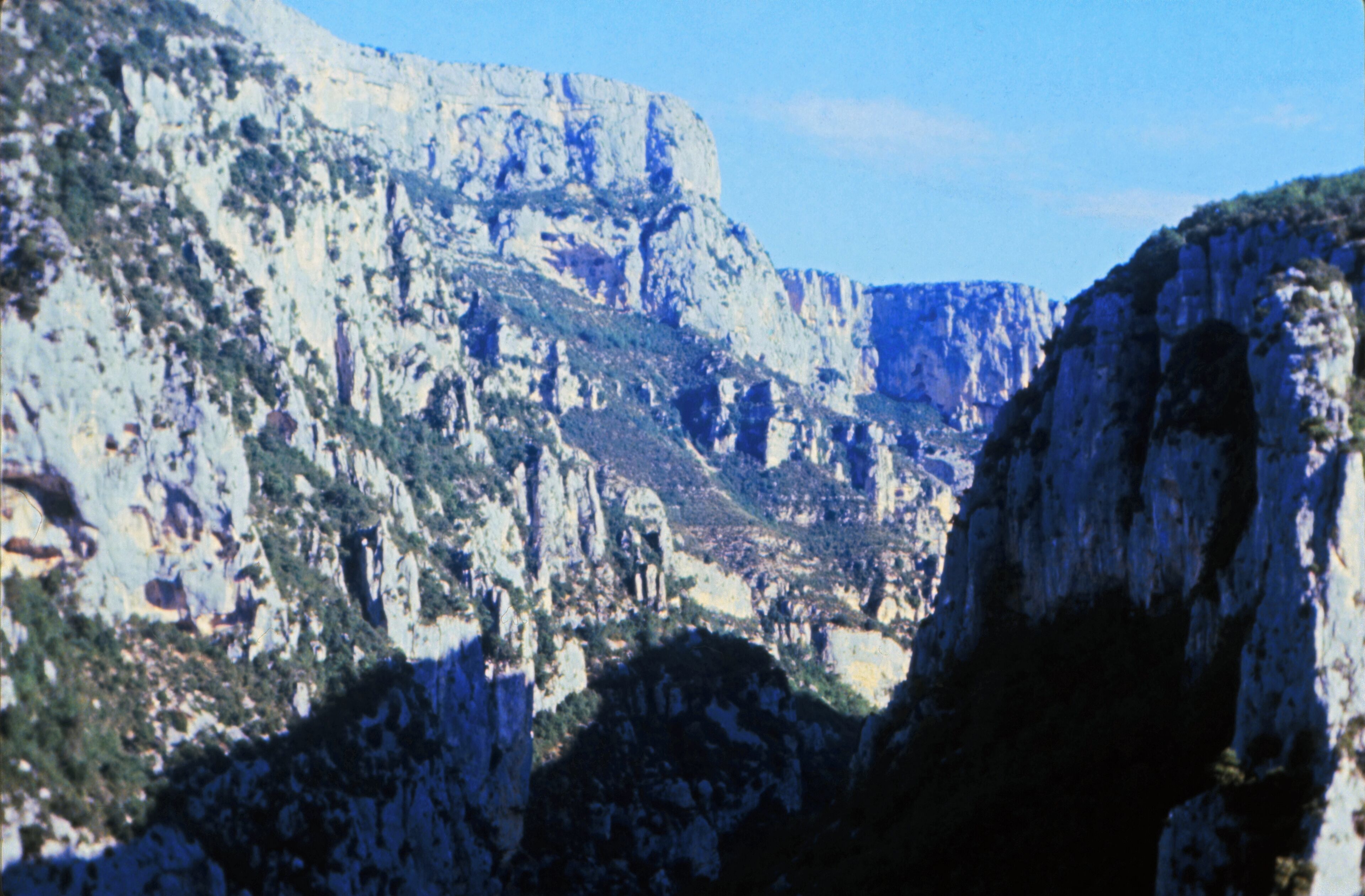 A rugged mountainous landscape with steep cliffs and sparse vegetation.
