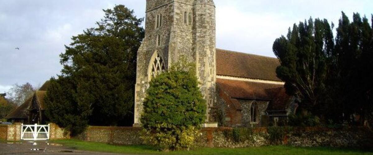 A historic stone church with a tall tower and a flag on top.