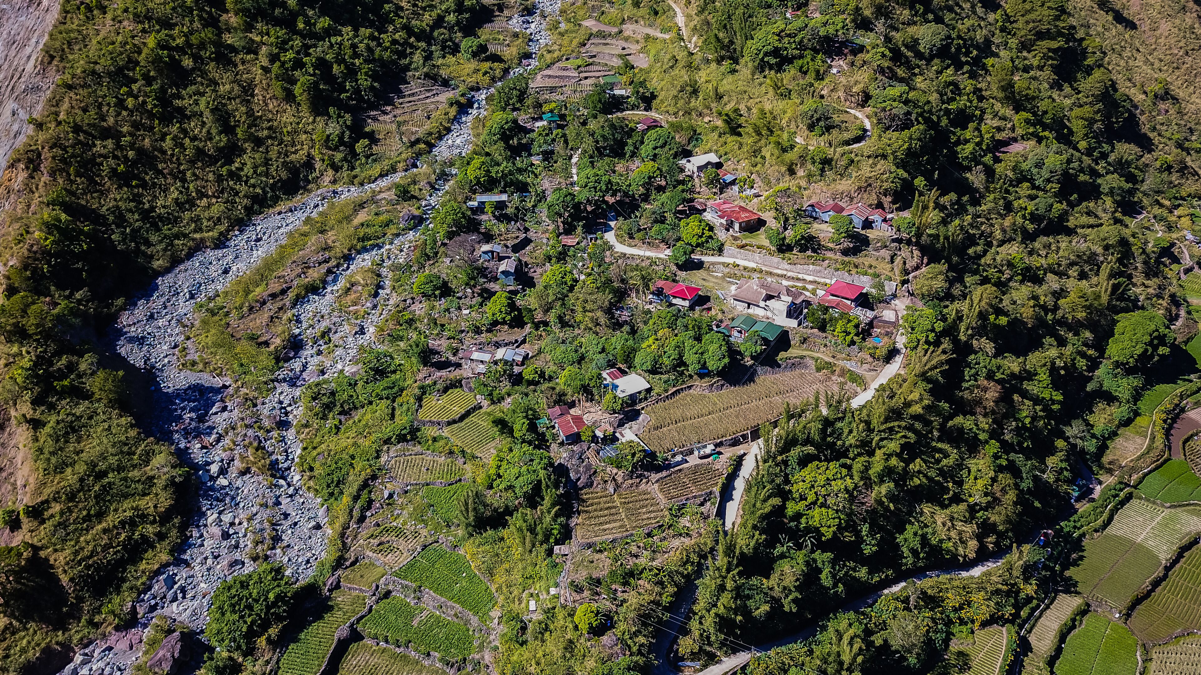 Aerial view of mountainous Kabayan in Benguet Philippines. Roads carve through the mountains along a river connecting communities business transpor