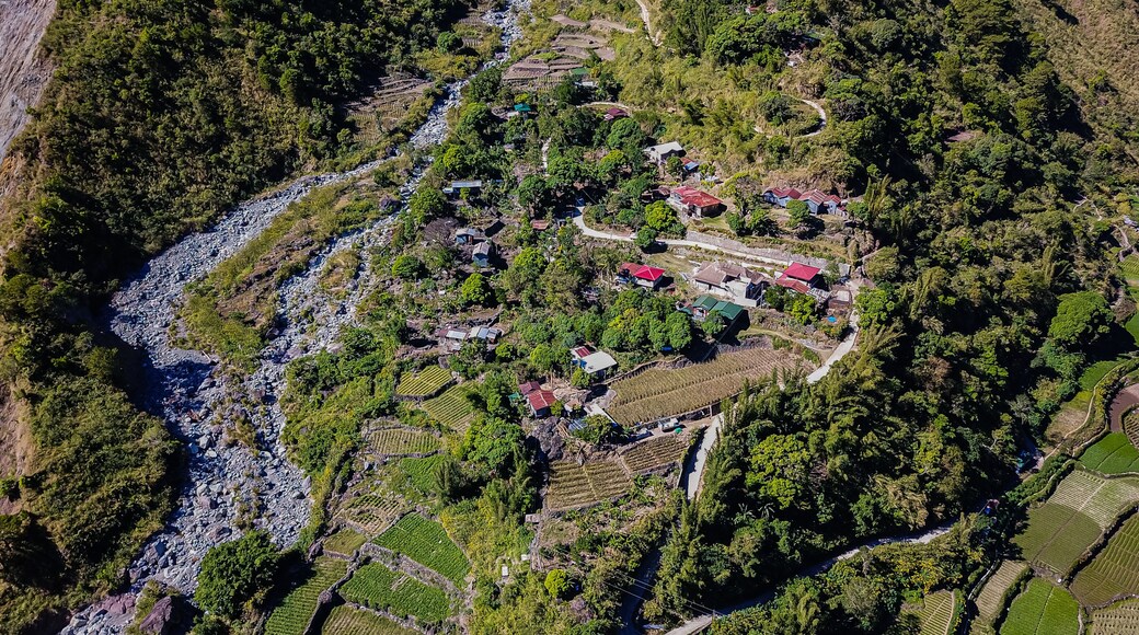 Aerial view of mountainous Kabayan in Benguet Philippines. Roads carve through the mountains along a river connecting communities business transpor