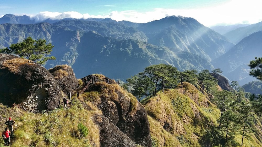 A mountainous landscape with hikers on a trail.