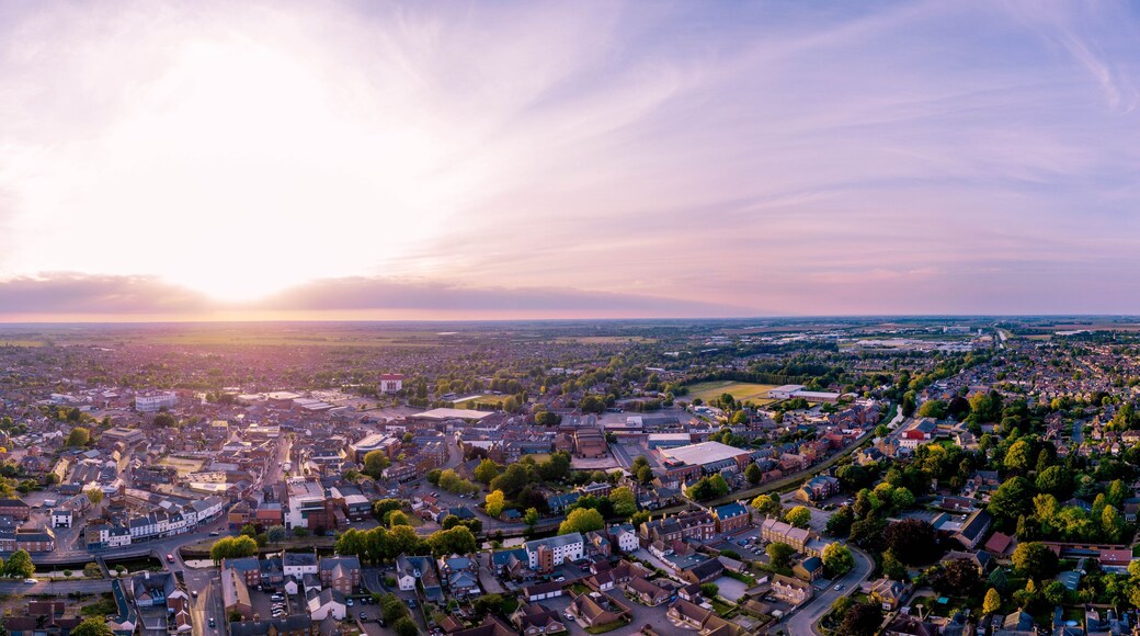 Ein Panoramablick auf eine Stadt bei Sonnenuntergang mit blauem Himmel und heller Sonne.