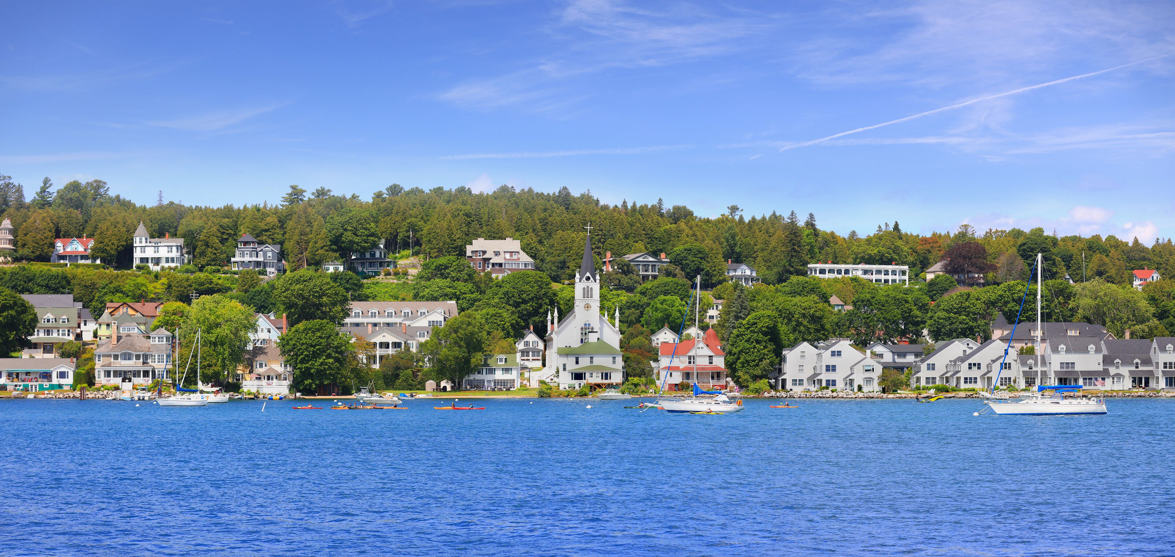 A coastal town with houses, a church, and boats on the water.