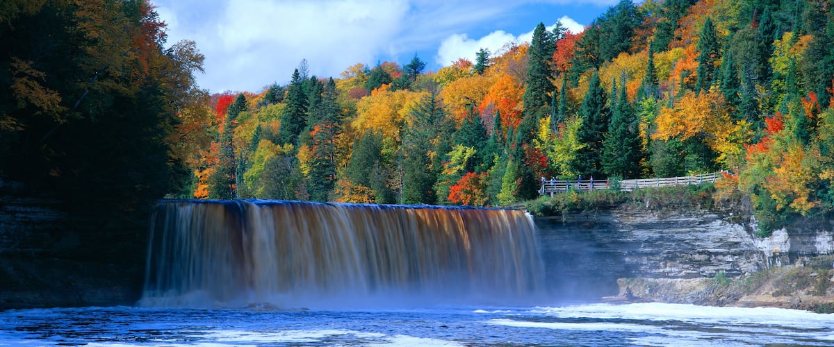 A waterfall surrounded by autumn foliage.