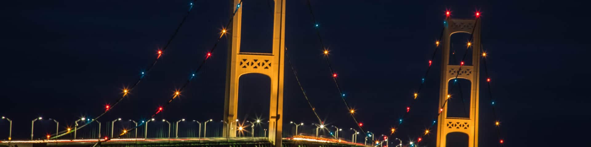 A bridge with two towers and colorful lights.