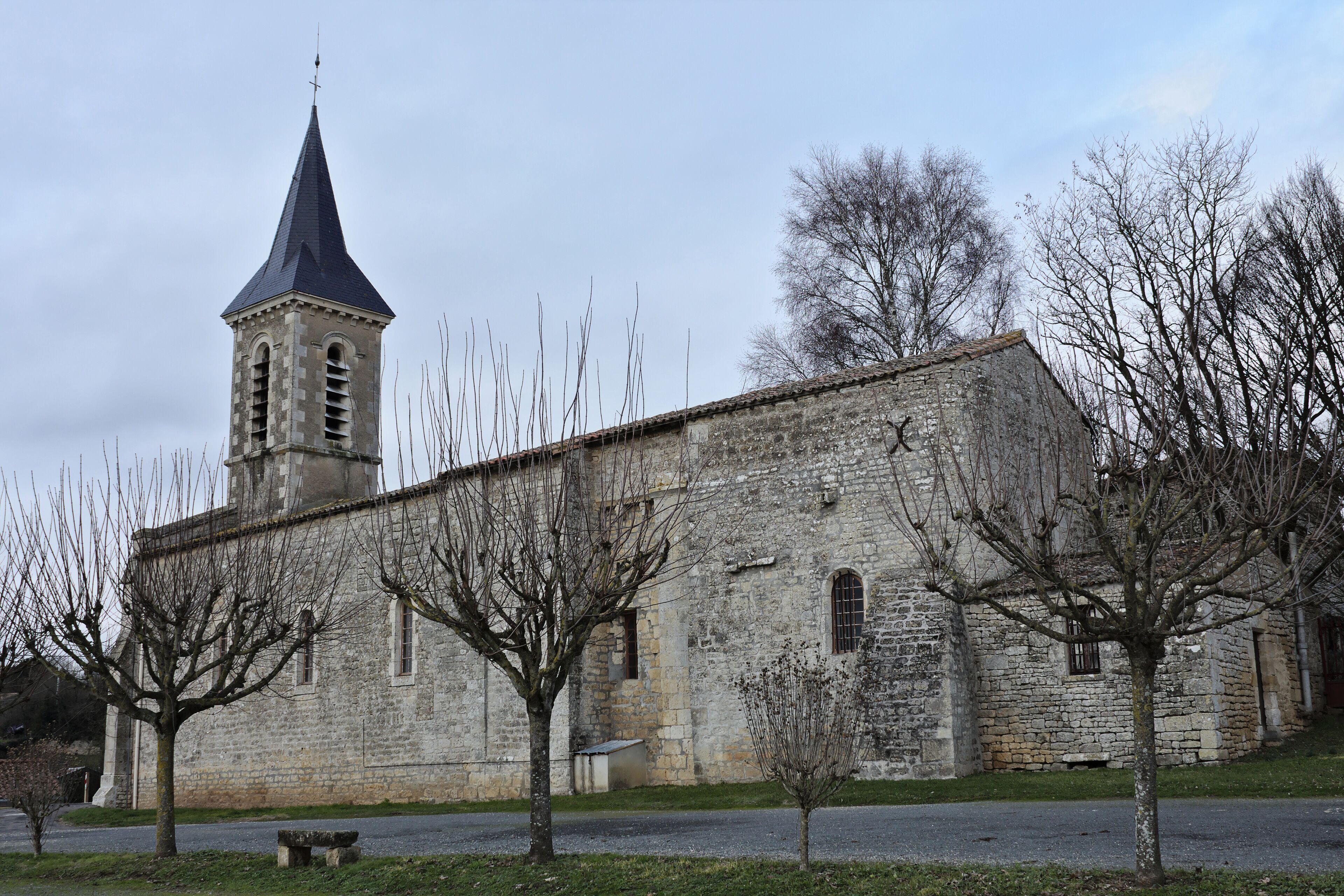 A stone church with a tall steeple and a bell tower.