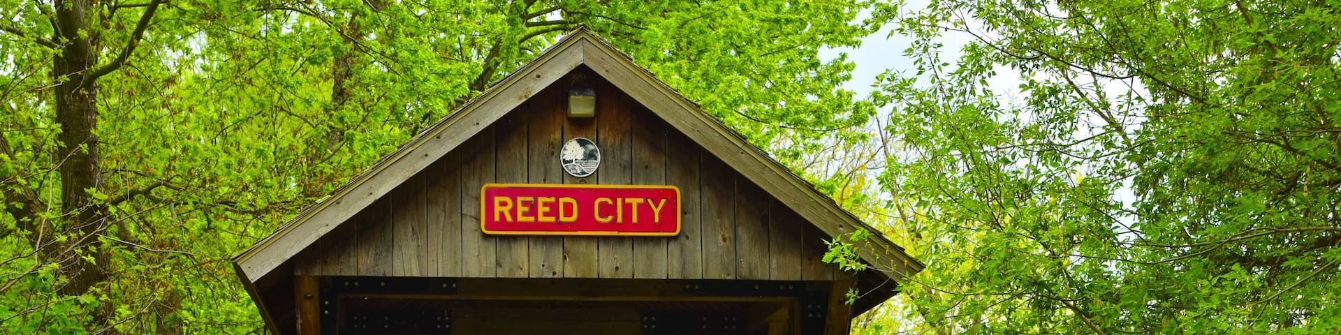 Covered wooden foot bridge over small peaceful creek in Reed City, Michigan.
