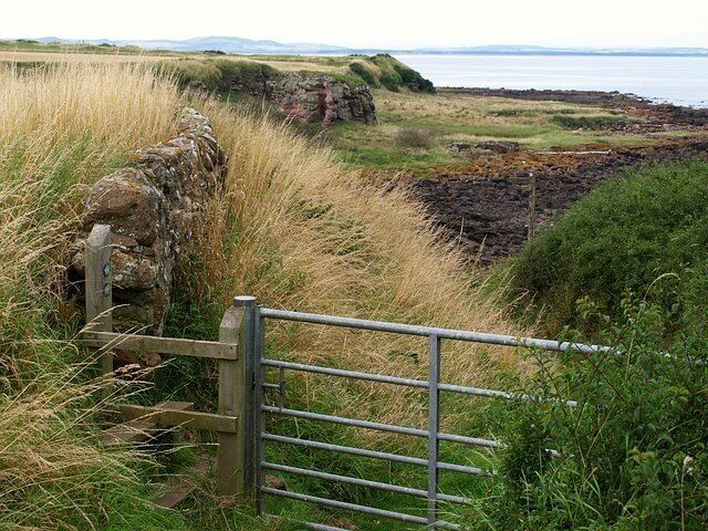 Coast path near Boarhills. For those heading west, the coast path becomes coastal once more, after a deviation inland up the Kenly Water valley and through Boarhills. Here the path passes through a gate and drops down the former cliff towards 118091, which is just left of centre.