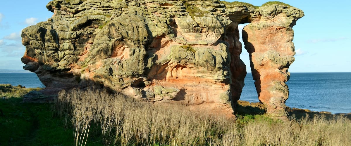 A large rock formation with a narrow passageway.