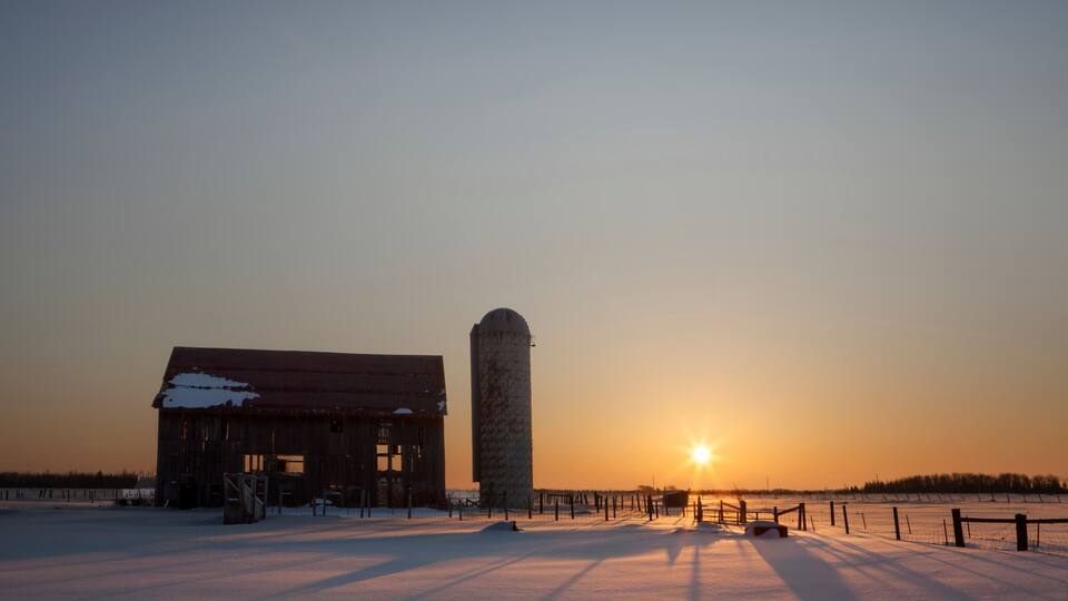 Dilapidated barn at sunrise in winter; Rudyard, Michigan, United States of America