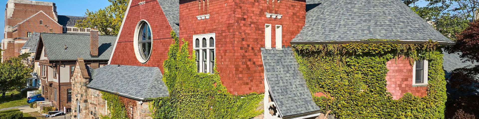 Aerial View of Ivy-Covered Victorian Brick House in Sunlight