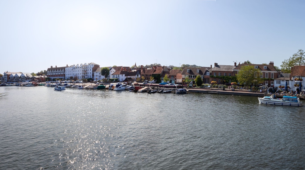 A river with boats, a stone bridge, and buildings along the riverbank.