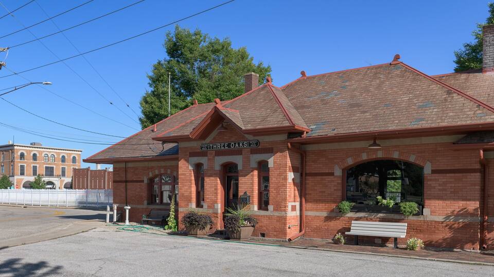 A brick building with a sign reading "Three Oaks."