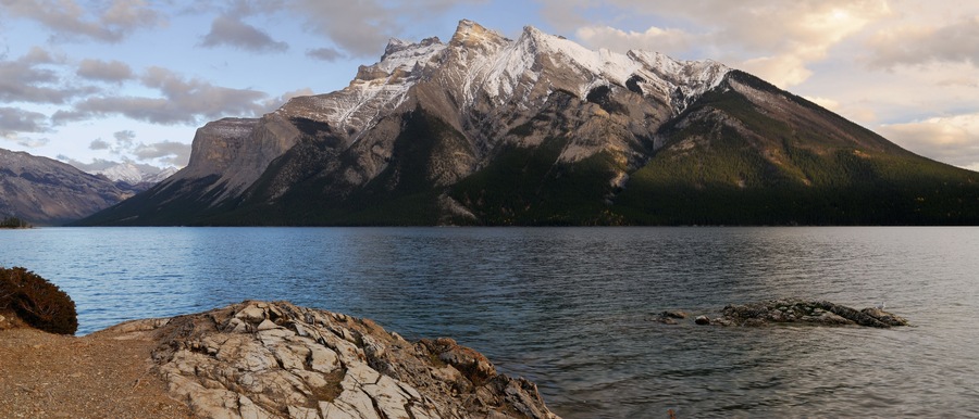 Une chaîne de montagnes avec un lac au premier plan.
