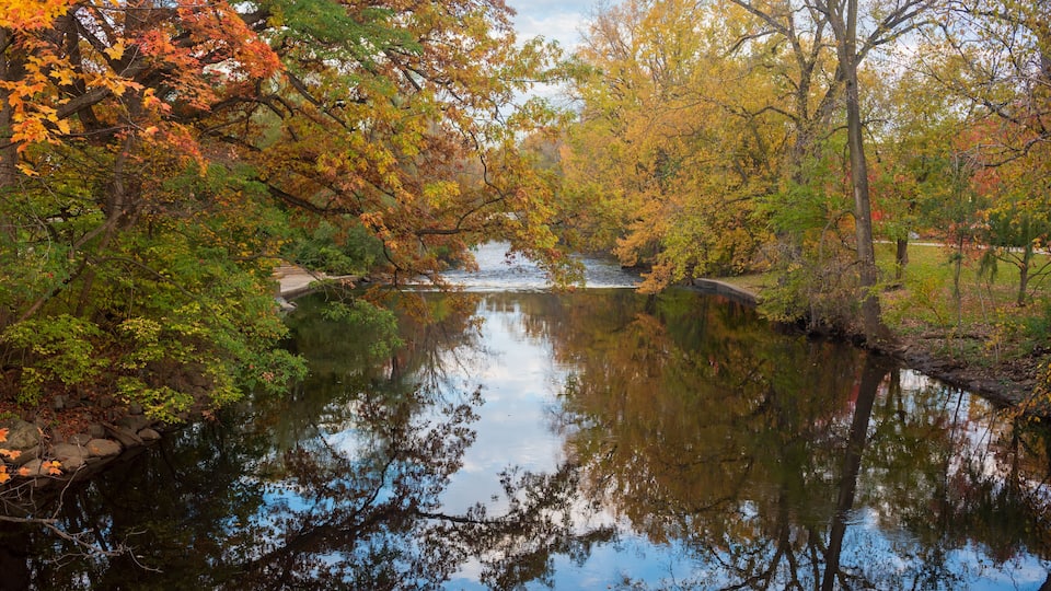 A calm river surrounded by autumn foliage.