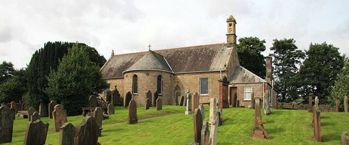 A church surrounded by gravestones in a cemetery.