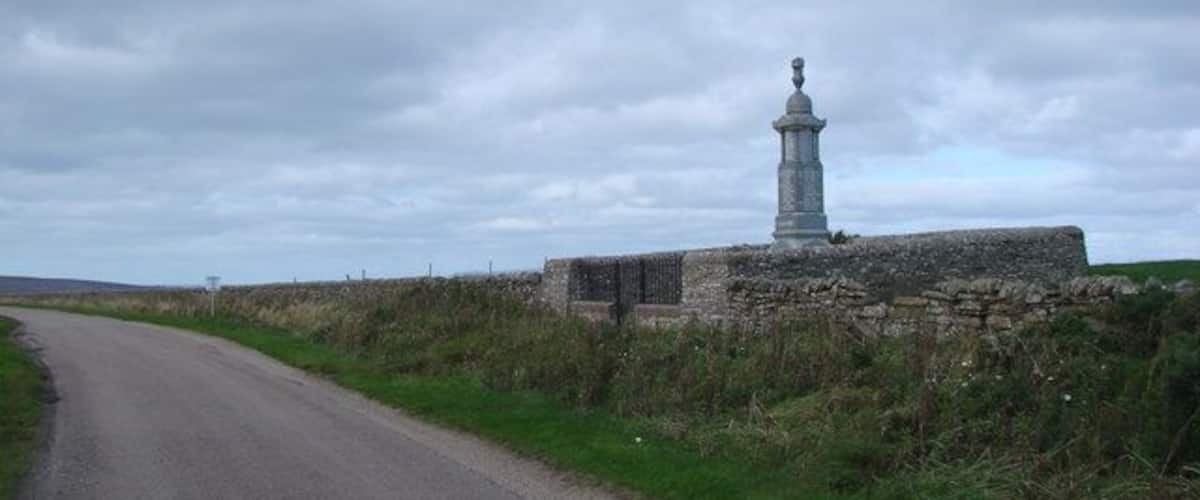 A rural road with a stone monument on the right.