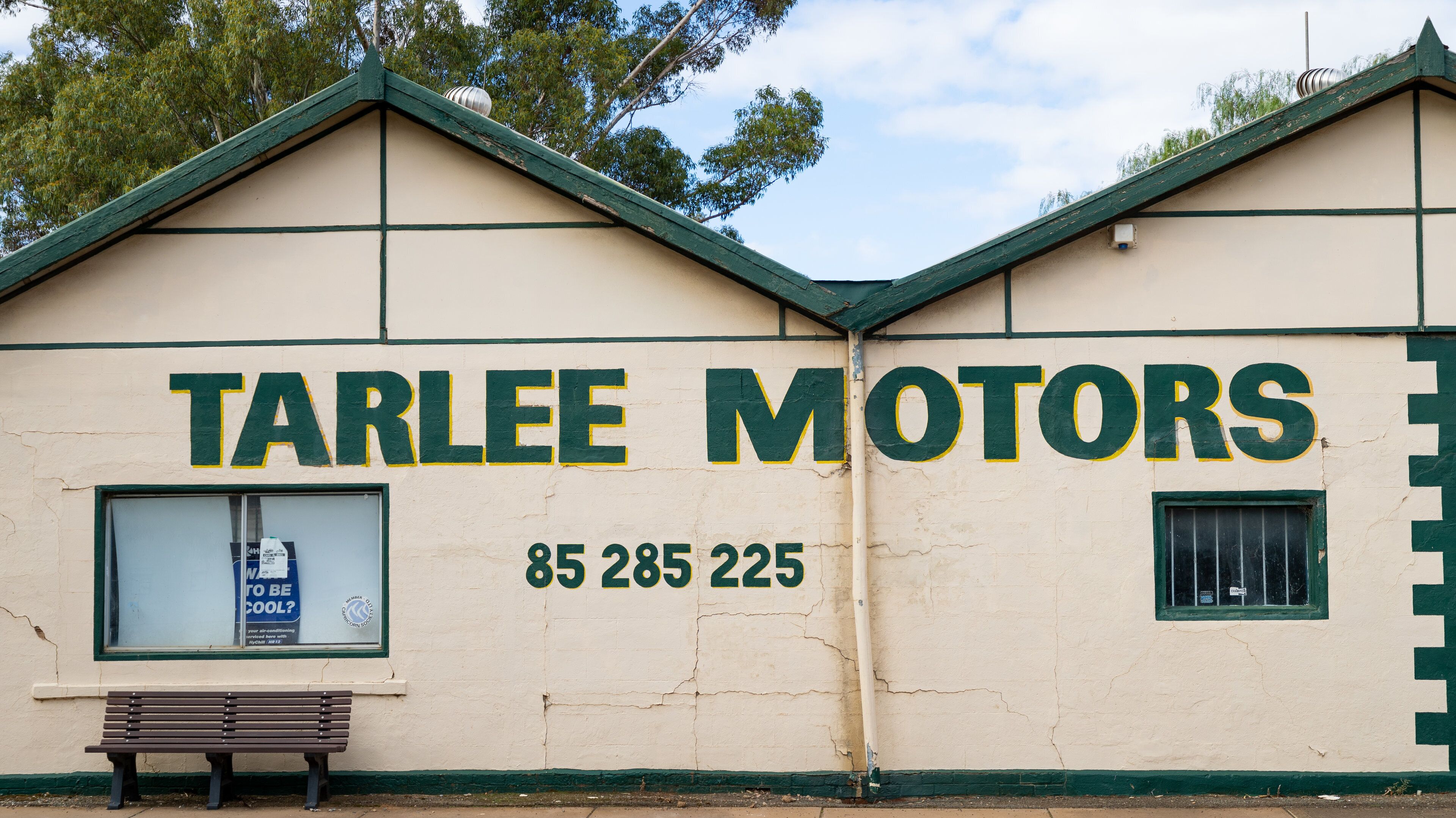 A building with the sign 'TARLEE MOTORS' and a phone number '85 285 225'.