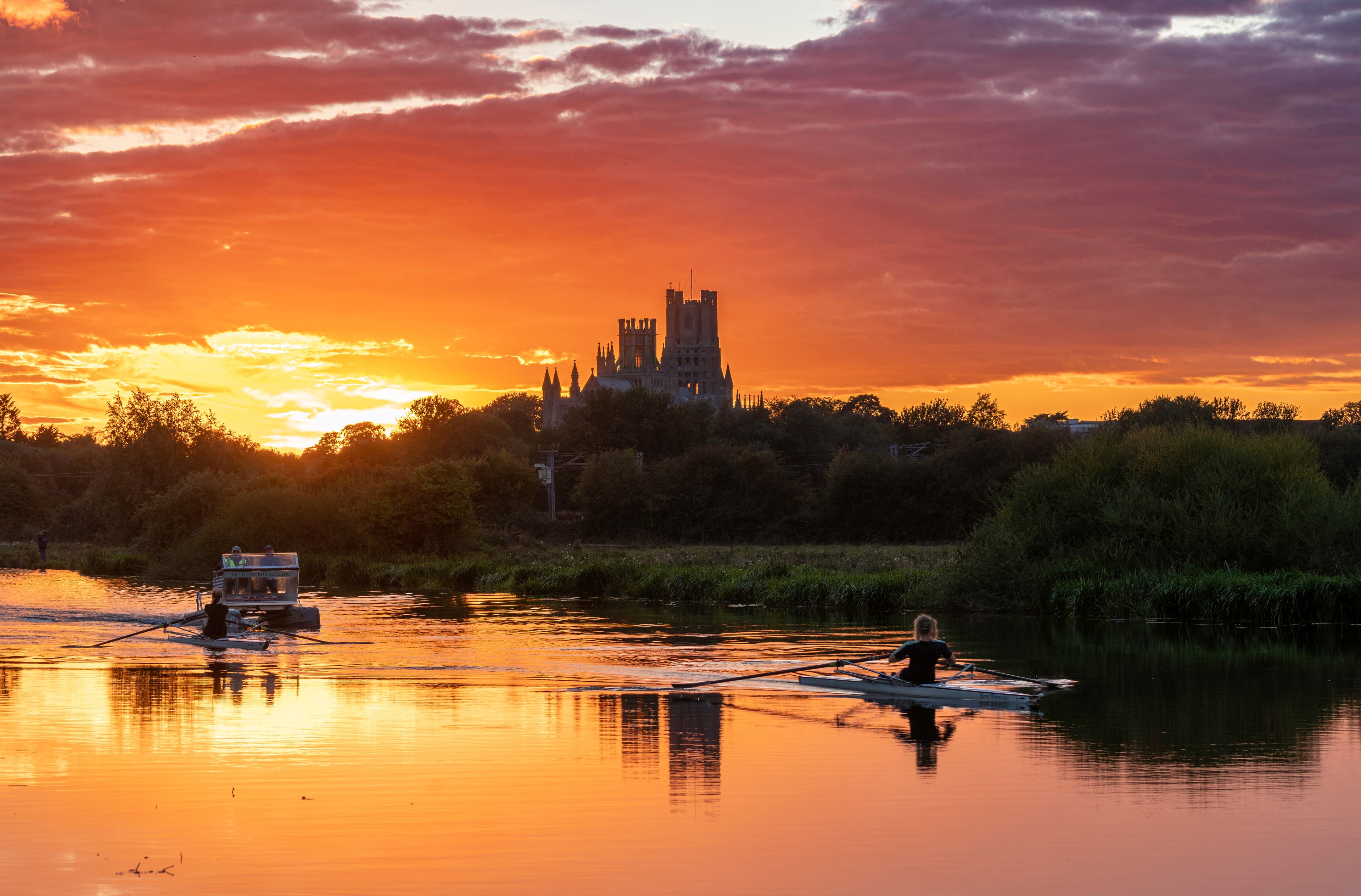 A sunset over a river with a castle in the background.