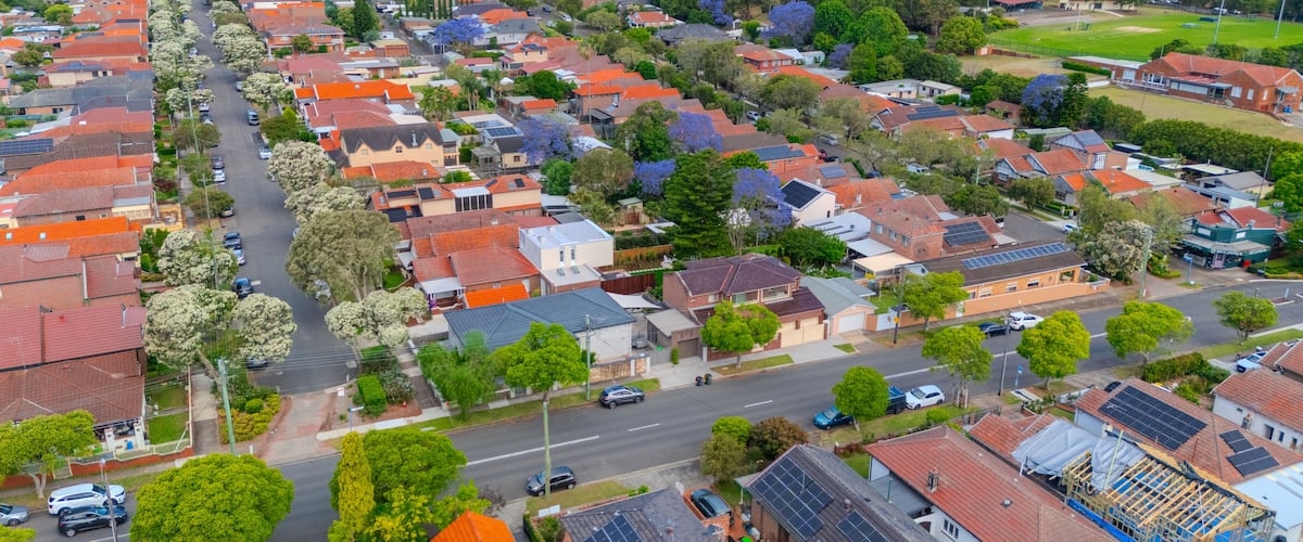 A residential area with houses, streets, and solar panels.