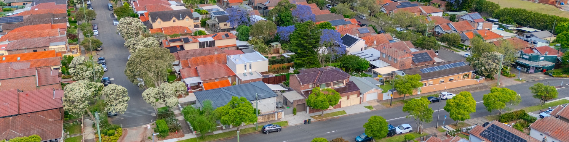 Uma área residencial com casas, ruas e painéis solares.