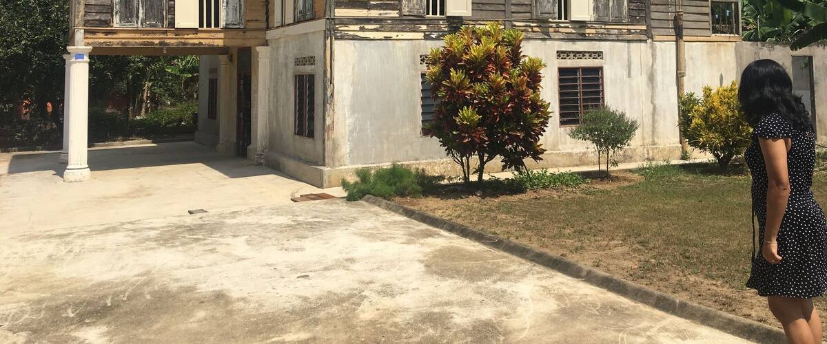 A two-story colonial-style building with a tiled roof and white shutters.