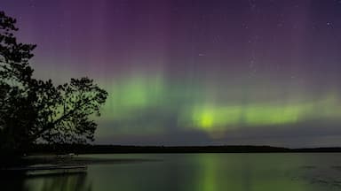 Northern Lights erupt in brilliant Aurora sky over Northern Minnesota Lake near Remer
