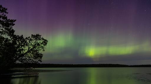 Northern Lights erupt in brilliant Aurora sky over Northern Minnesota Lake near Remer