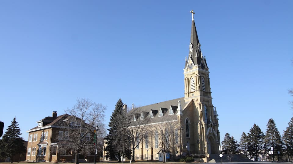 A church with a tall steeple and a clock tower.