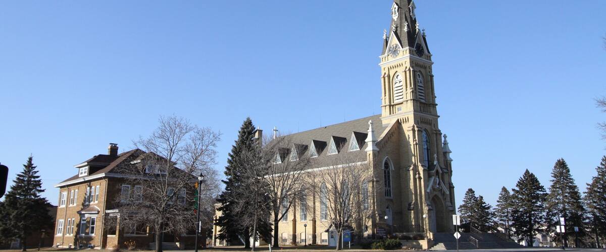 A church with a tall steeple and a clock tower.