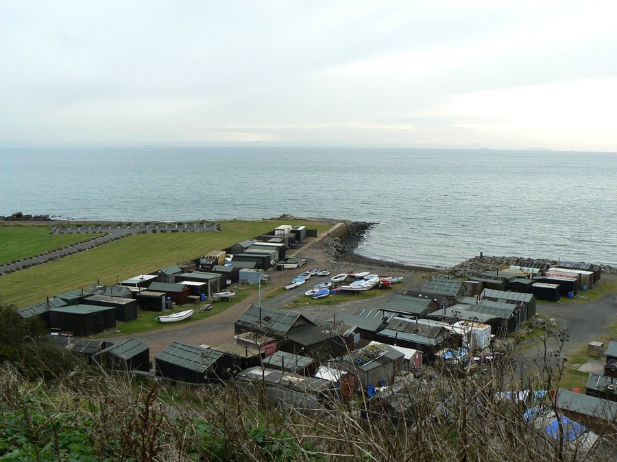 Un village côtier avec de petites maisons et des bateaux au bord de la mer.