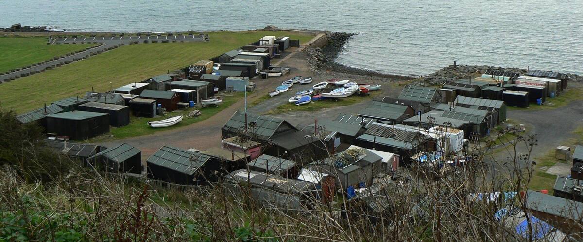 A coastal village with small houses and boats by the sea.