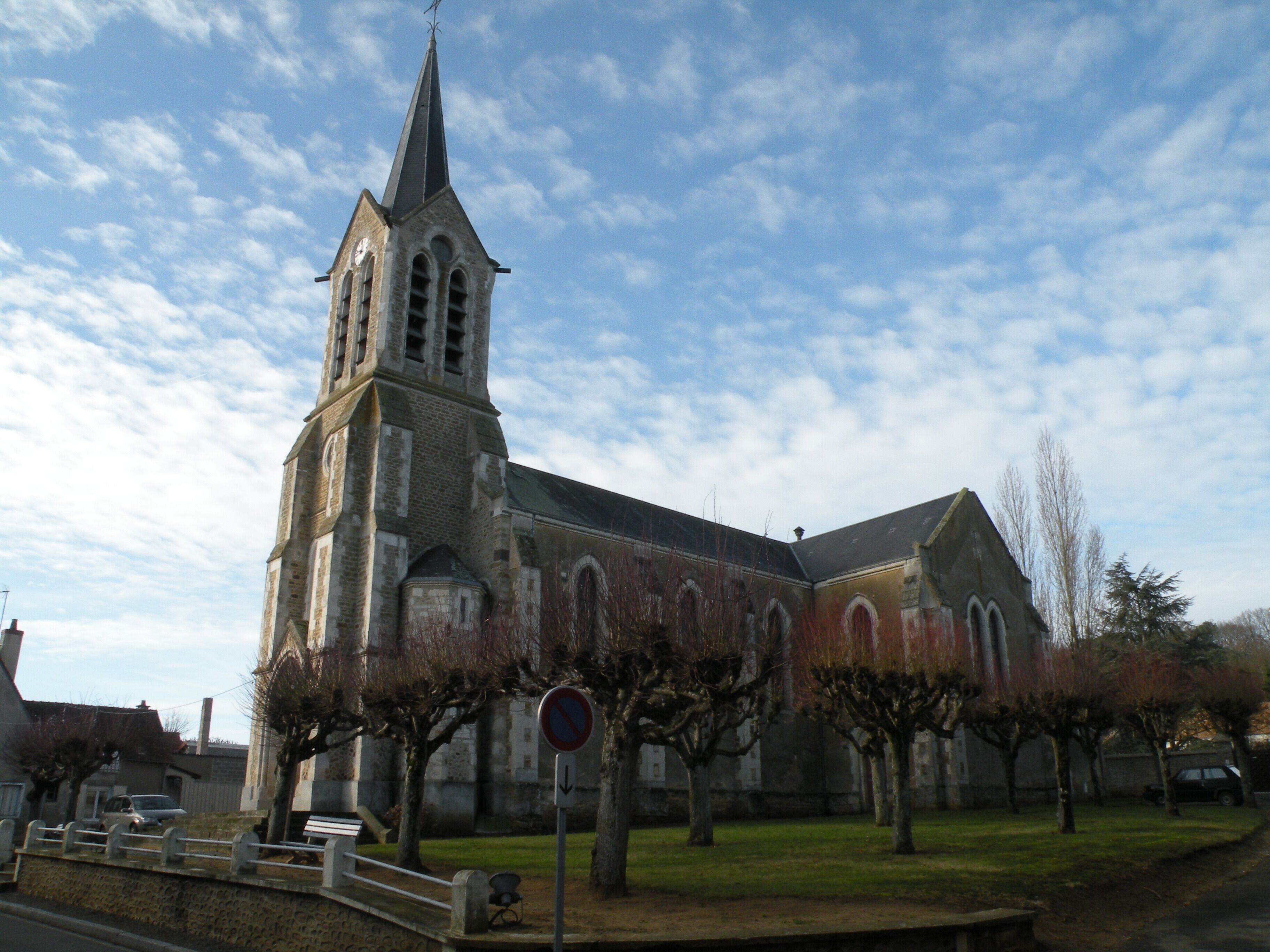A church with a tall steeple and arched windows.