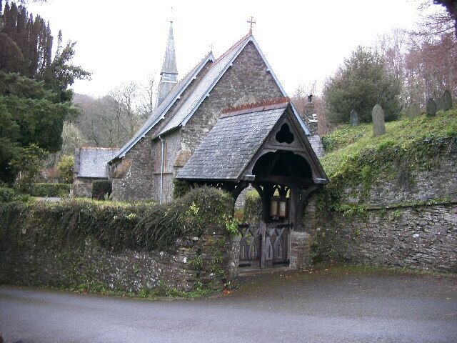 A stone church with a pointed roof and a bell tower.