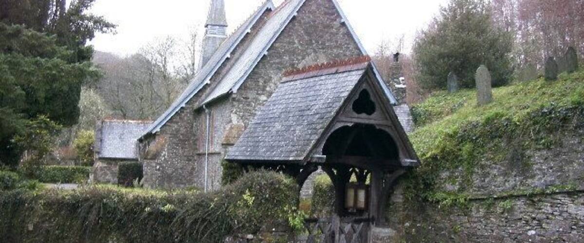 A stone church with a pointed roof and a bell tower.