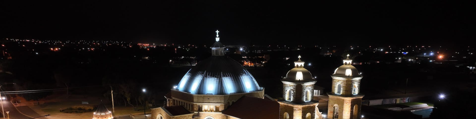 A large, illuminated church with a prominent dome and multiple towers.