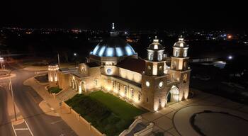 Una iglesia grande e iluminada con una cúpula destacada y varias torres.