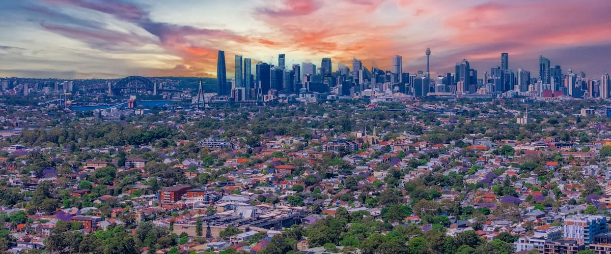 A city skyline with modern skyscrapers and a sunset sky.