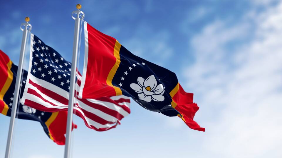 Mississippi state flag waving with the American flag on a clear day