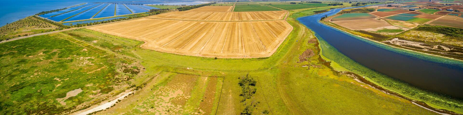 Aerial panorama of Werribee river, plowed field, and Western water treatment plant. Cocoroc, Victoria, Australia