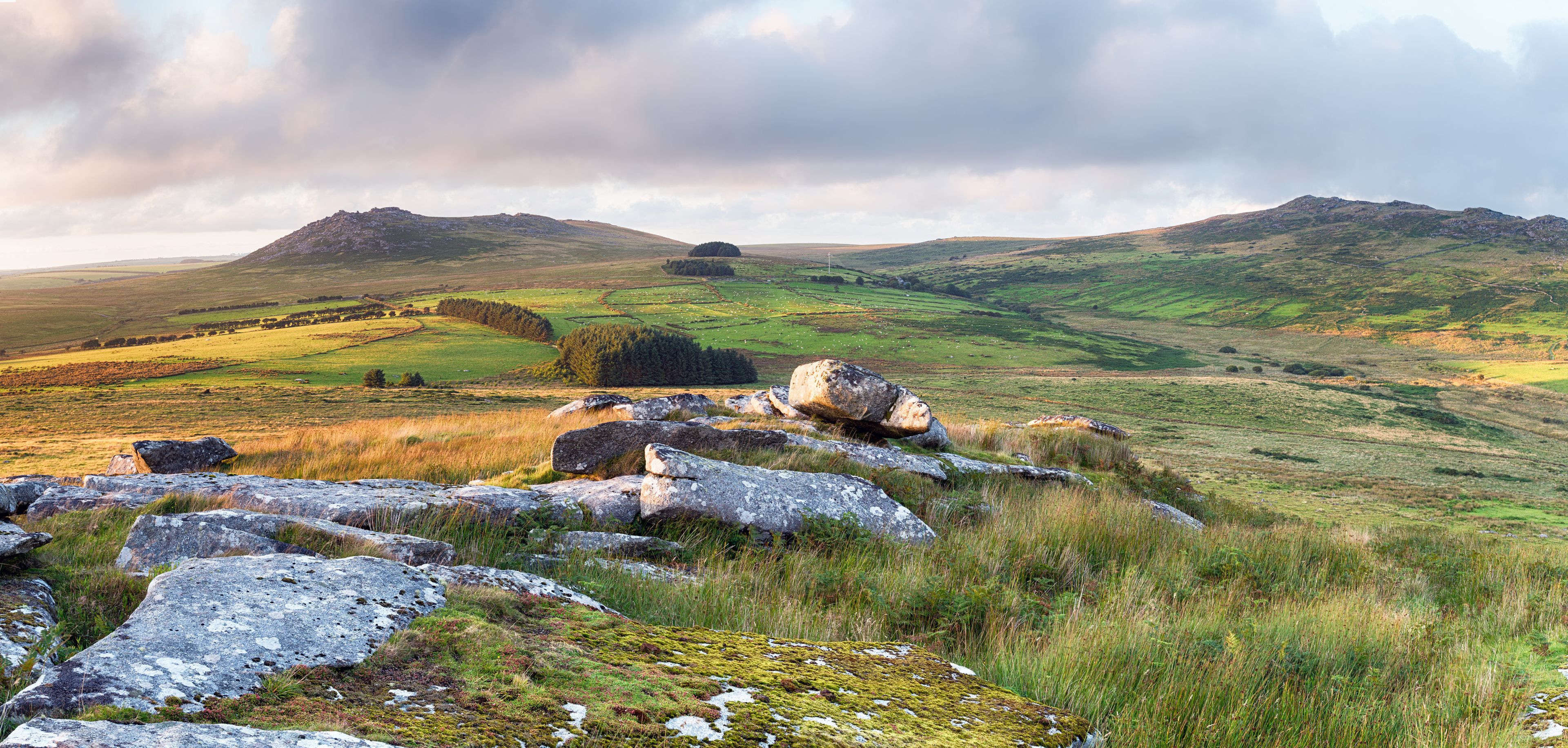 A mountainous landscape with rocky outcrops and grassy fields.