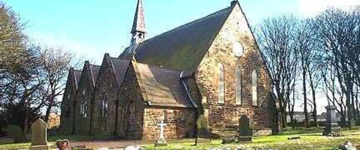 A church with a steeple, surrounded by a cemetery with headstones.