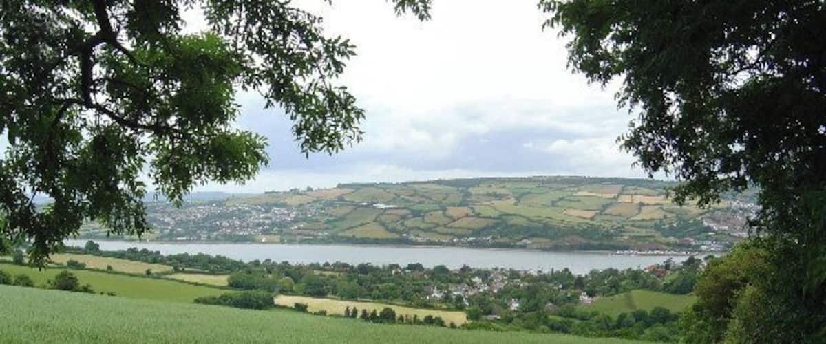 A green field, a lake, and a town in the distance.