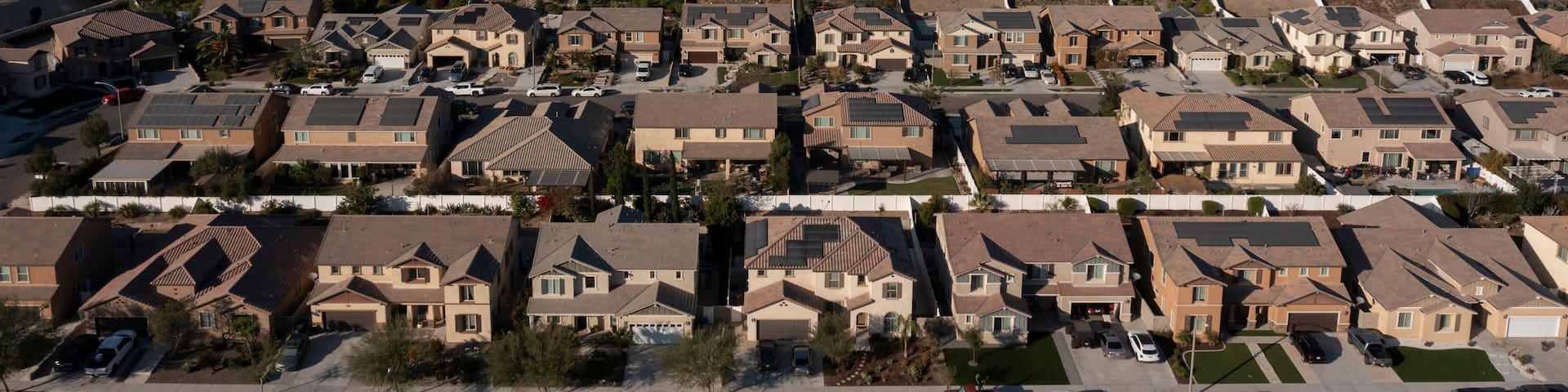 Jurupa Valley, California, USA - November 9, 2024: Afternoon sun shines on newly constructed industrial warehouses and suburban homes.