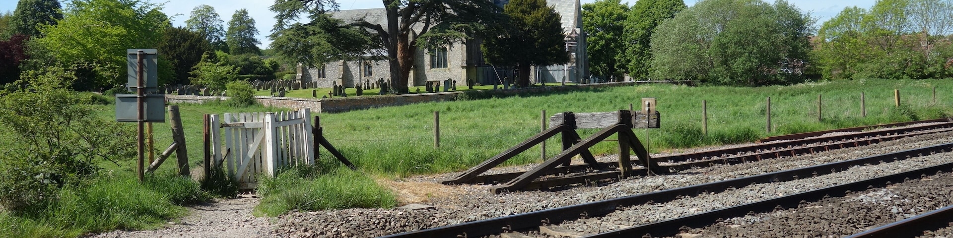 Footpath crossing the tracks. A shortcut from the canal towpath past the church into the south end of the village. The buffer stop marks the end of the commuter line which runs between Bedwyn and London Paddington. Trains arriving at Bedwyn shunt onto this siding where they wait off the main line before heading back to London again.