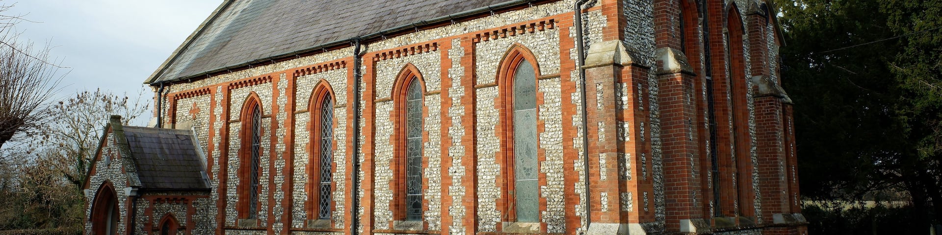 A church with a stone facade, arched windows, and a steeple.