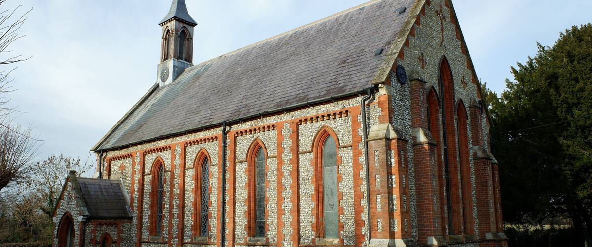 A church with a stone facade, arched windows, and a steeple.